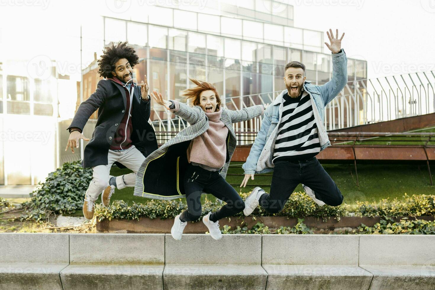 drei glücklich freunde Springen im das Stadt foto