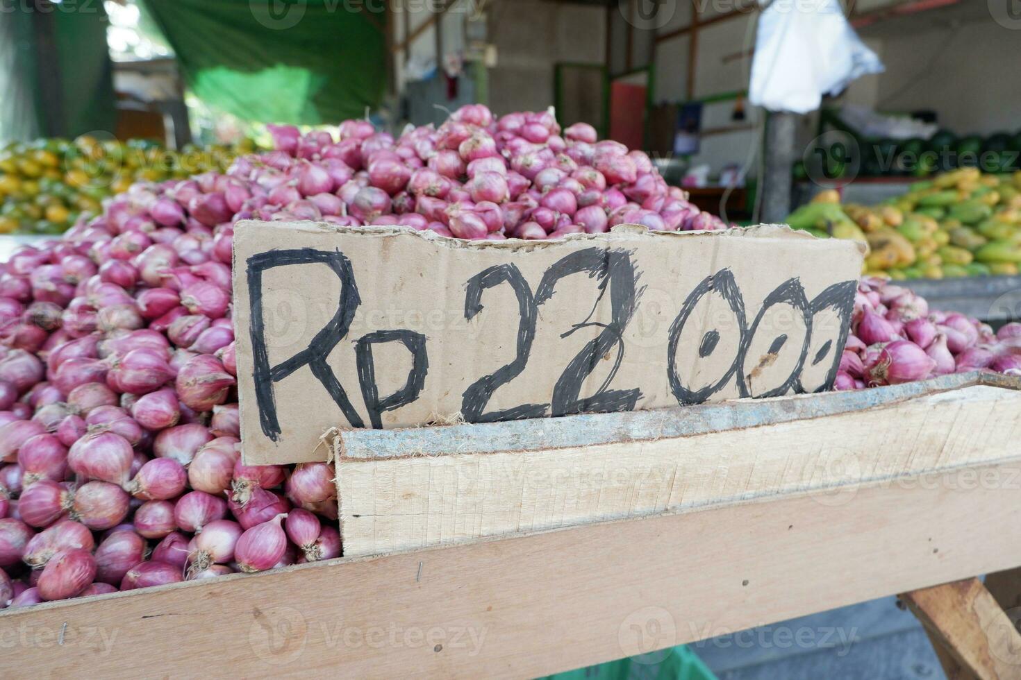 das rp Symbol von das indonesisch Währung mit ein Stapel von Schalotten im das Hintergrund. das Konzept von Zwiebel Preise steigend und fallen foto