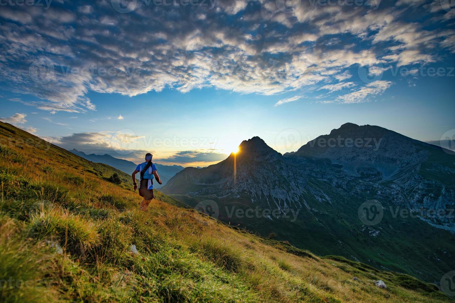 Skyrunner Läufer läuft in den Bergen, wenn die Sonne aufgeht foto