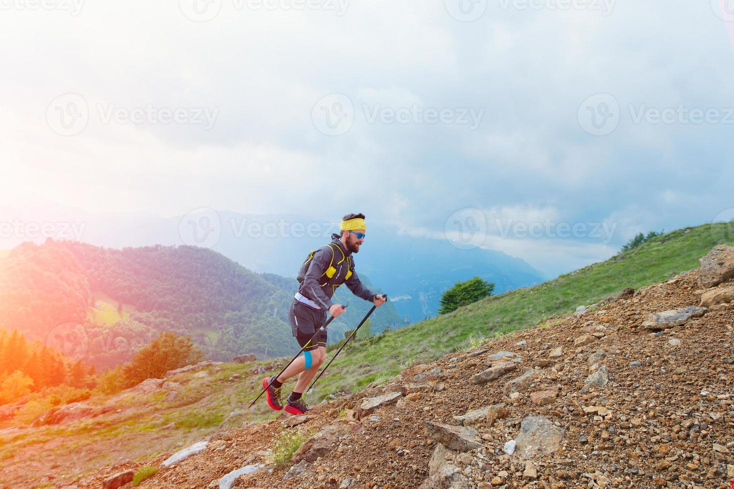 Skyrunner Athlet beim Training in den Bergen mit Stöcken foto