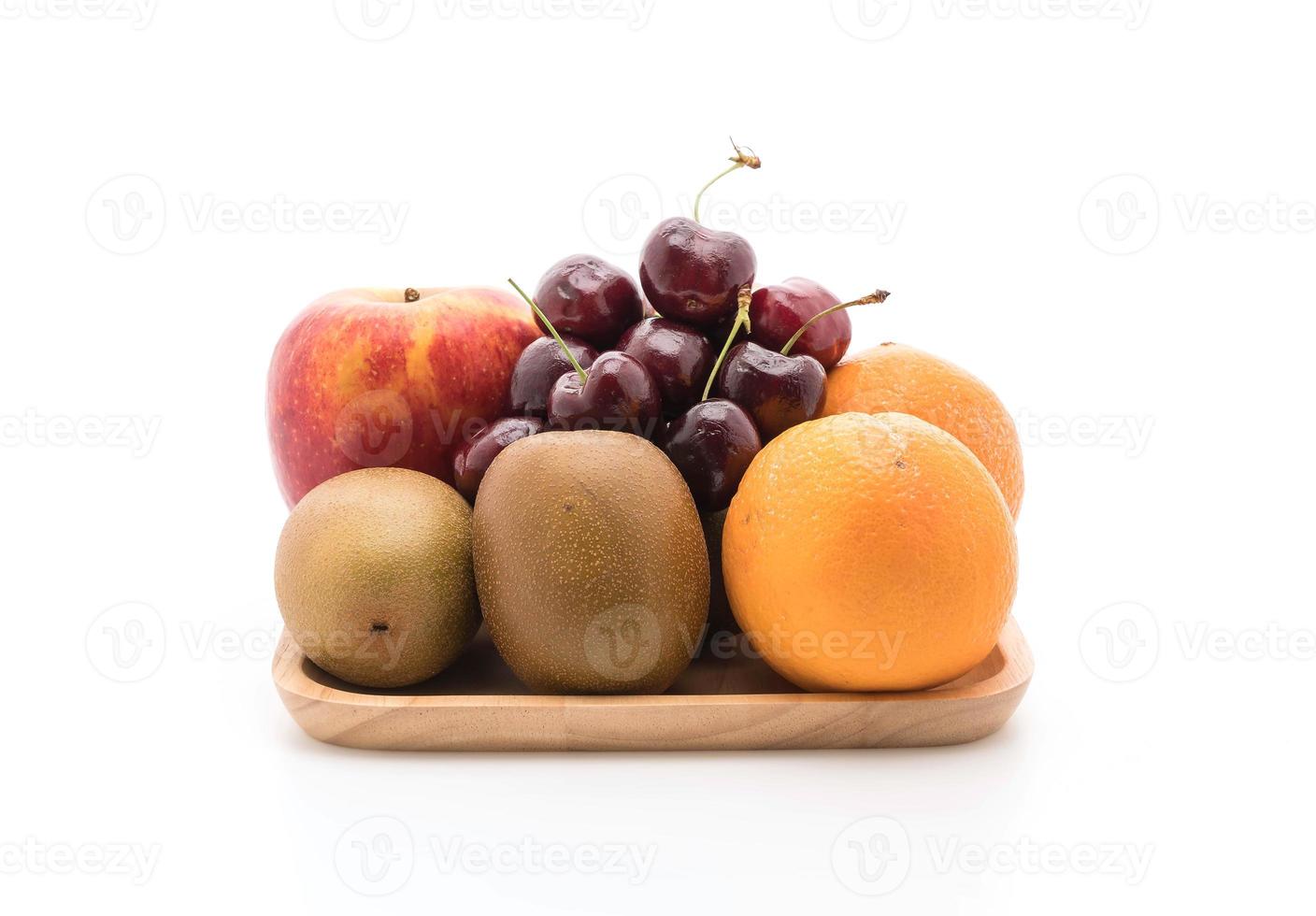 gemischtes Obst in Holzplatte auf weißem Hintergrund foto