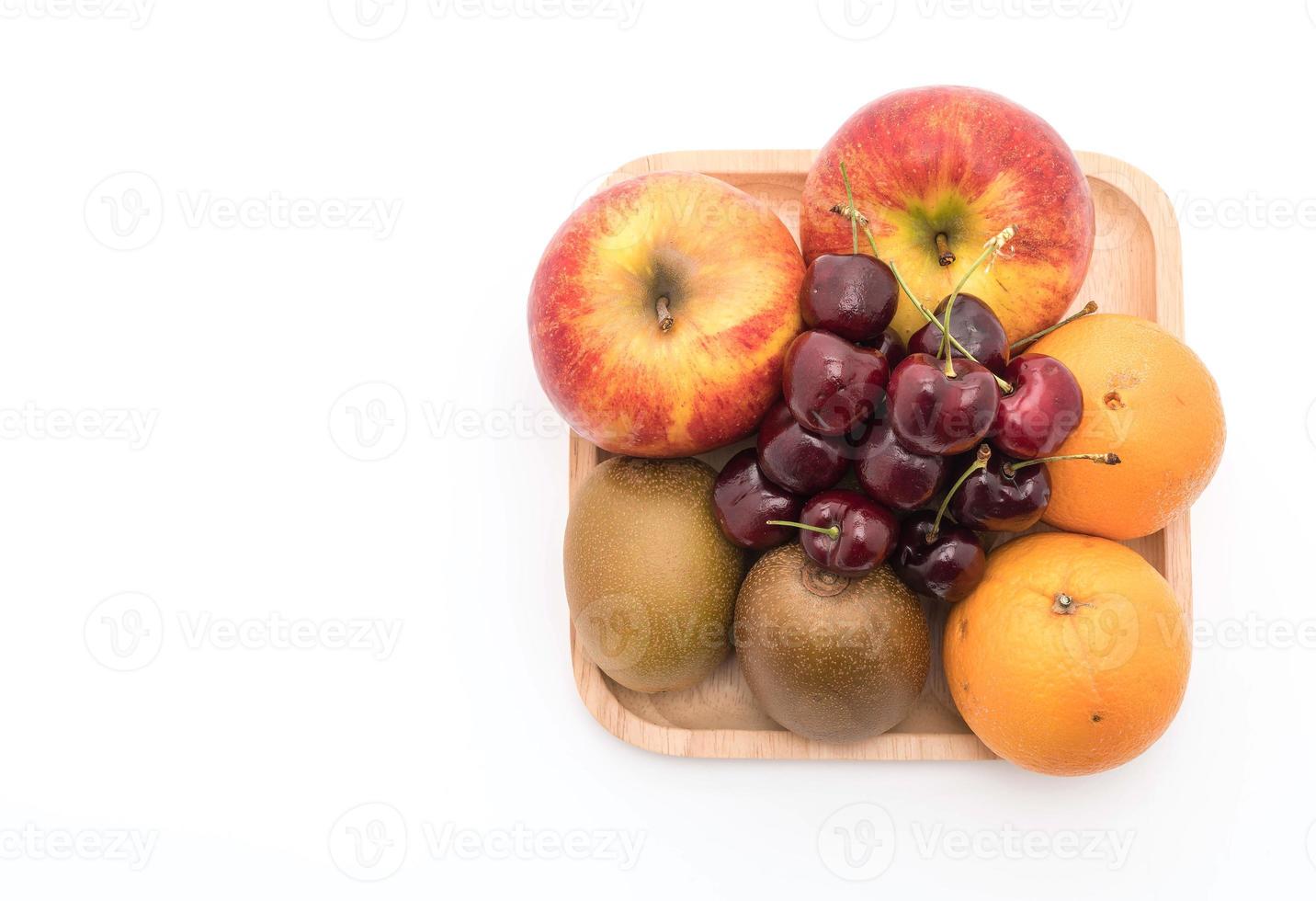 gemischtes Obst in Holzplatte auf weißem Hintergrund foto