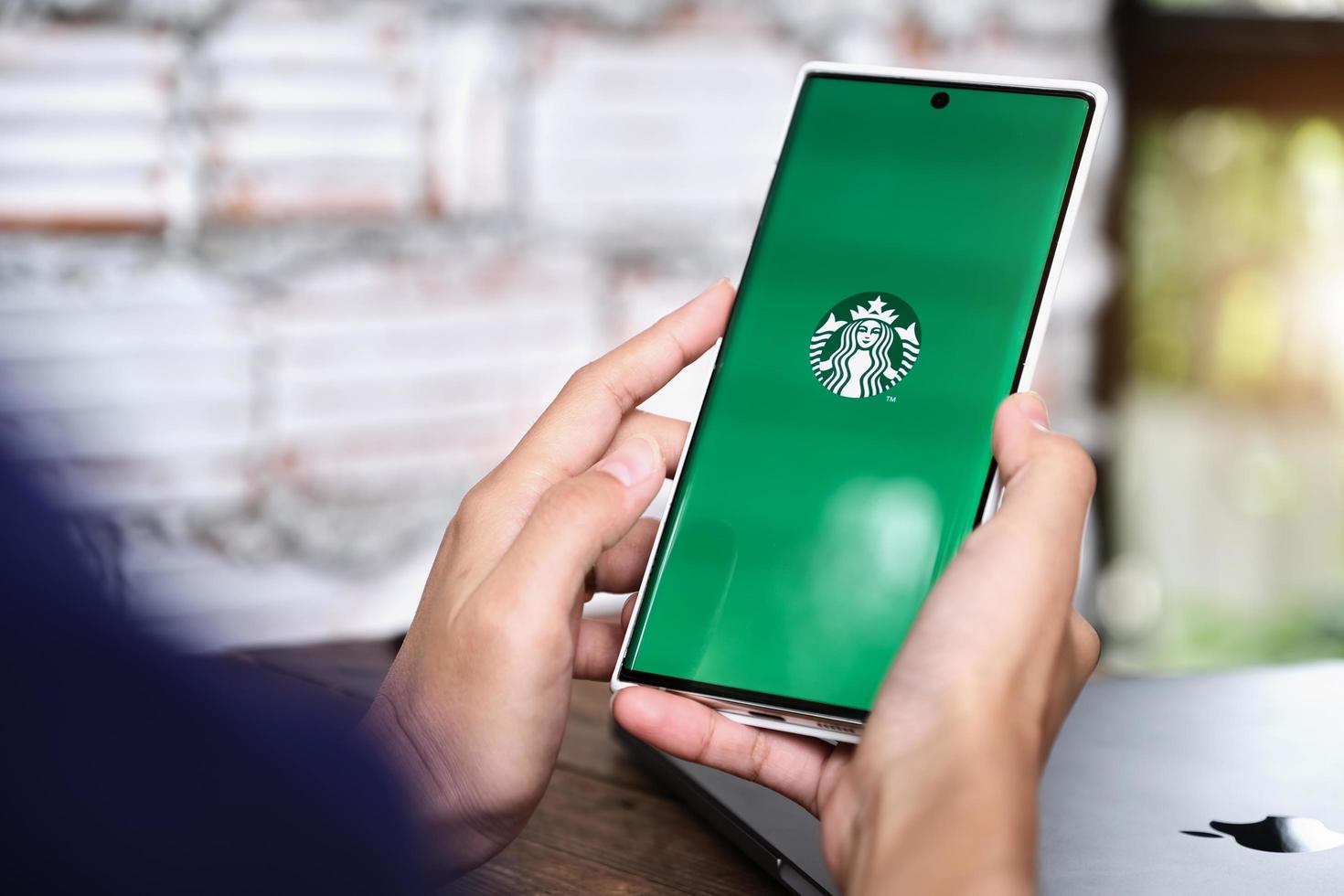 Chiang Mai, Thailand 2021 - Frau hält Smartphone mit Starbucks-Anwendung auf dem Bildschirm foto