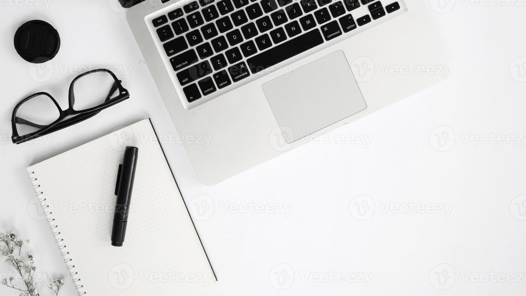 Draufsicht Laptop und Brille auf weißem Hintergrund foto