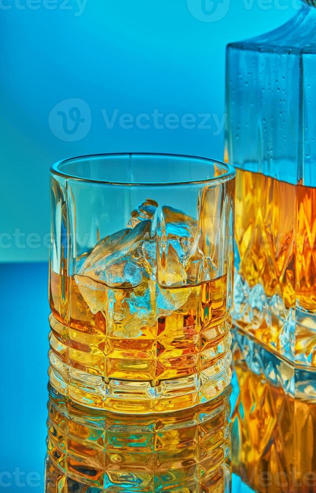 eine Glas- und quadratische Kristallkaraffe mit Scotch Whisky oder Brandy foto