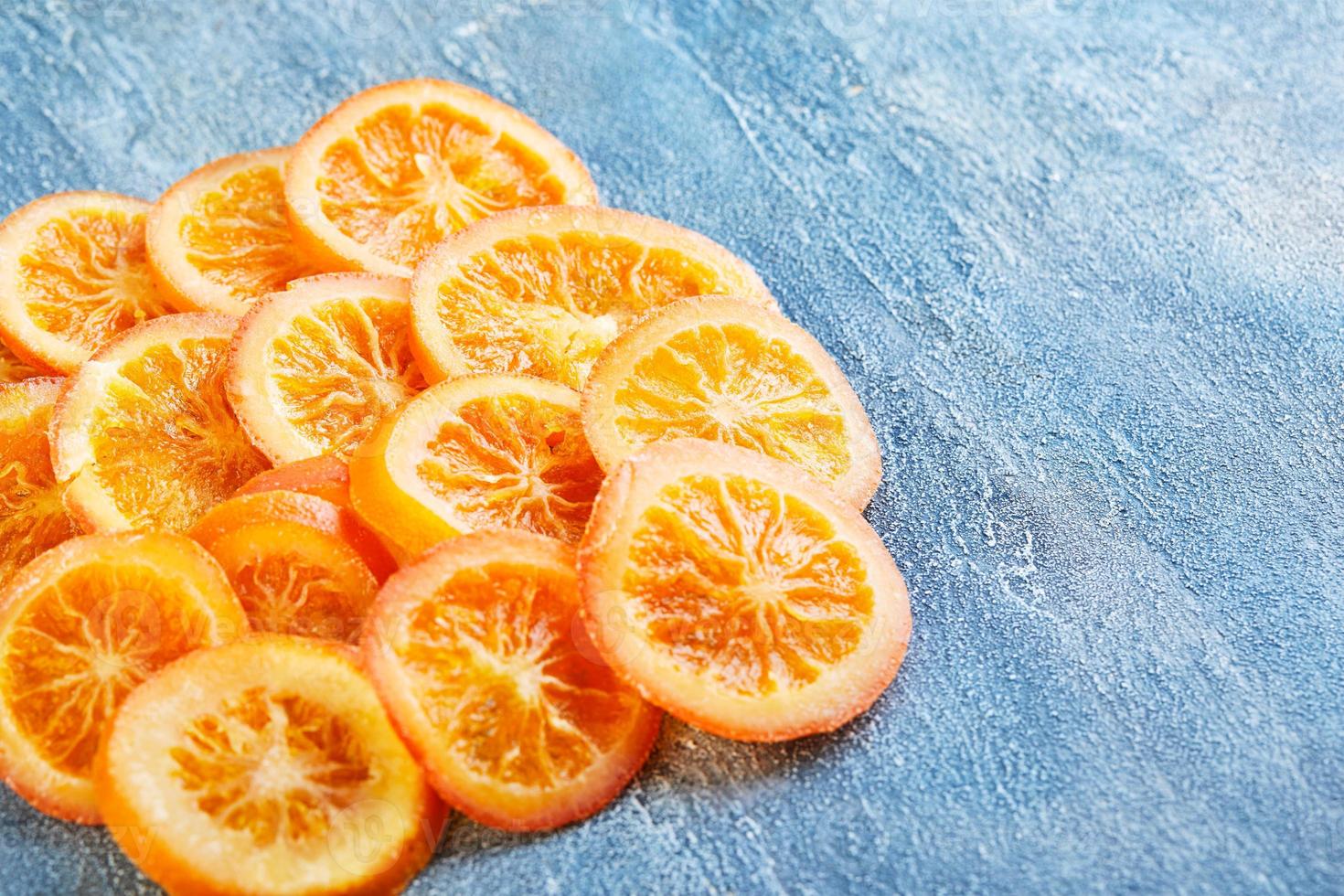 Scheiben von getrockneten Orangen oder Mandarinen auf blauem Hintergrund foto