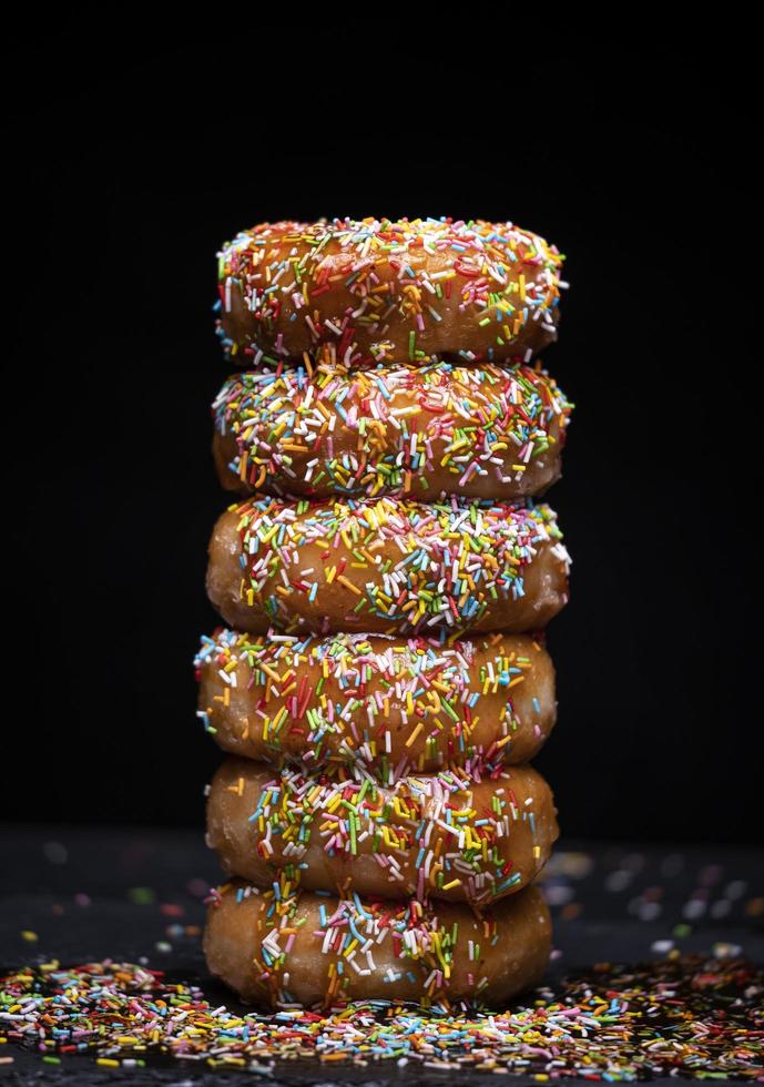 Donutsberg mit Erdbeersirup und buntem Topping foto