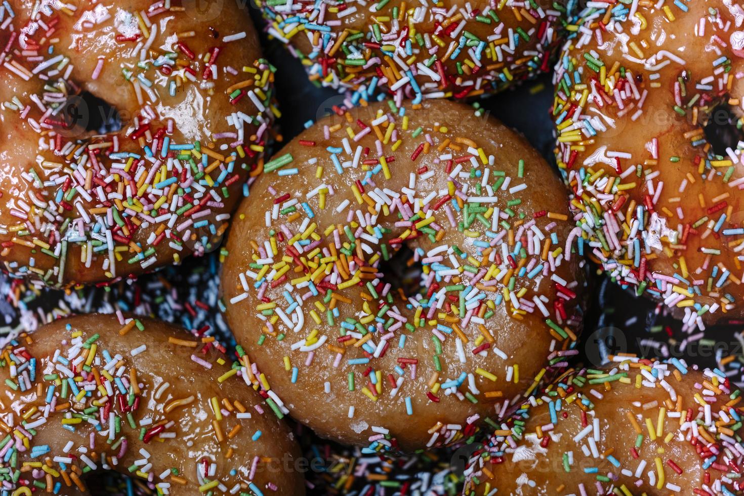 Donuts mit Erdbeersirup und buntem Topping foto