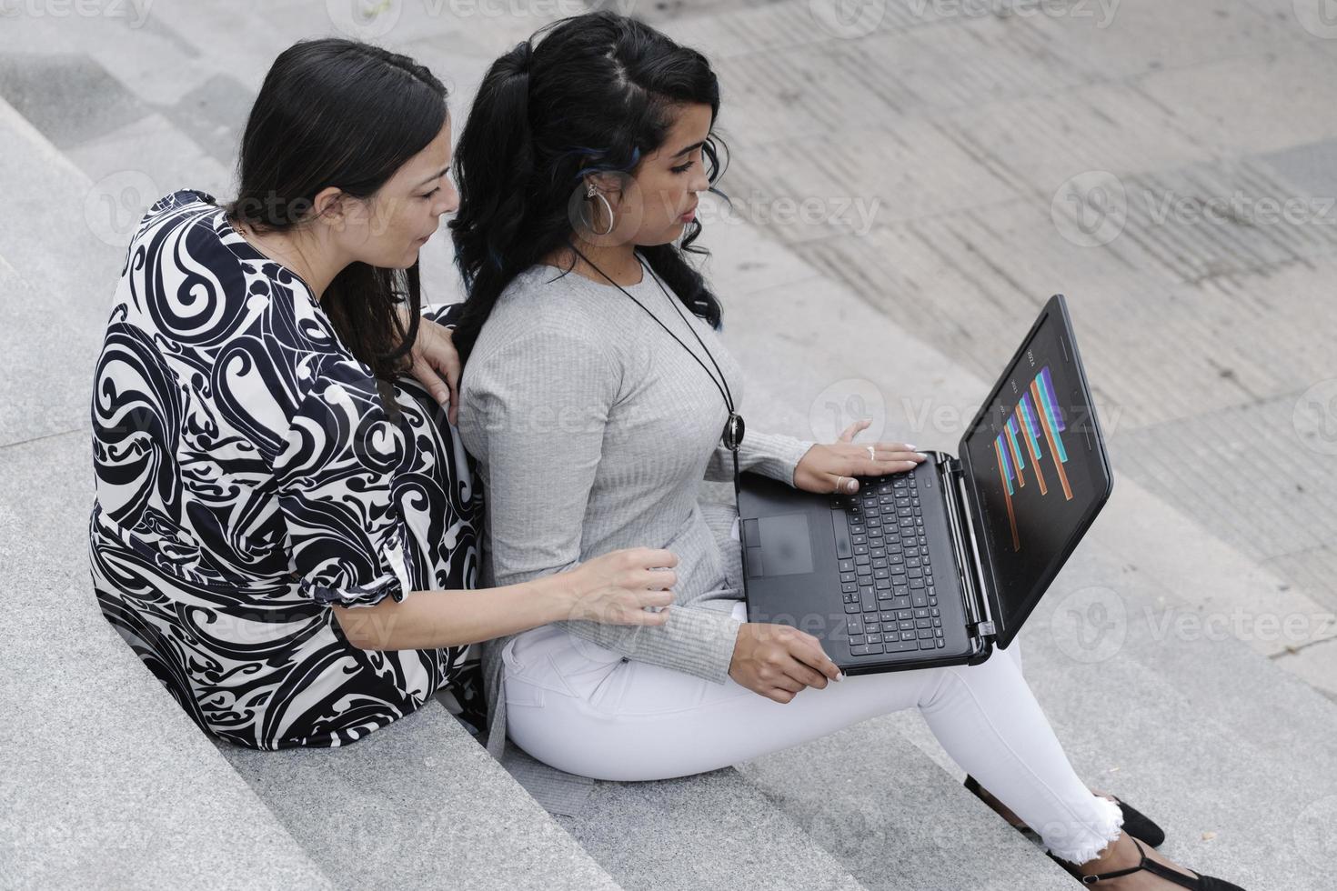 Geschäftsfrauen, die mit einem Laptop im Freien arbeiten foto