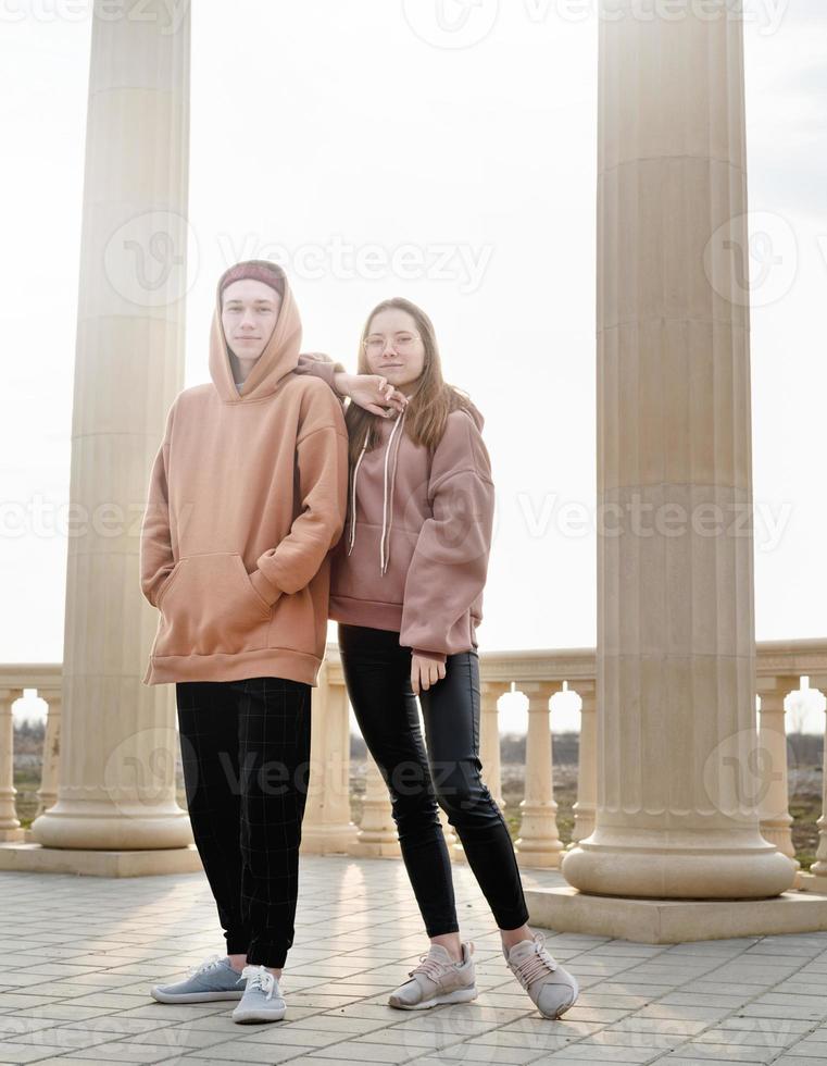 junges Paar oder Freunde, die draußen im Park zusammenstehen foto