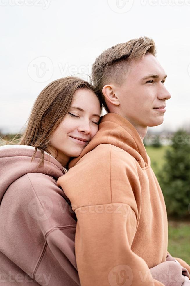 junges Liebespaar umarmt sich draußen im Park foto