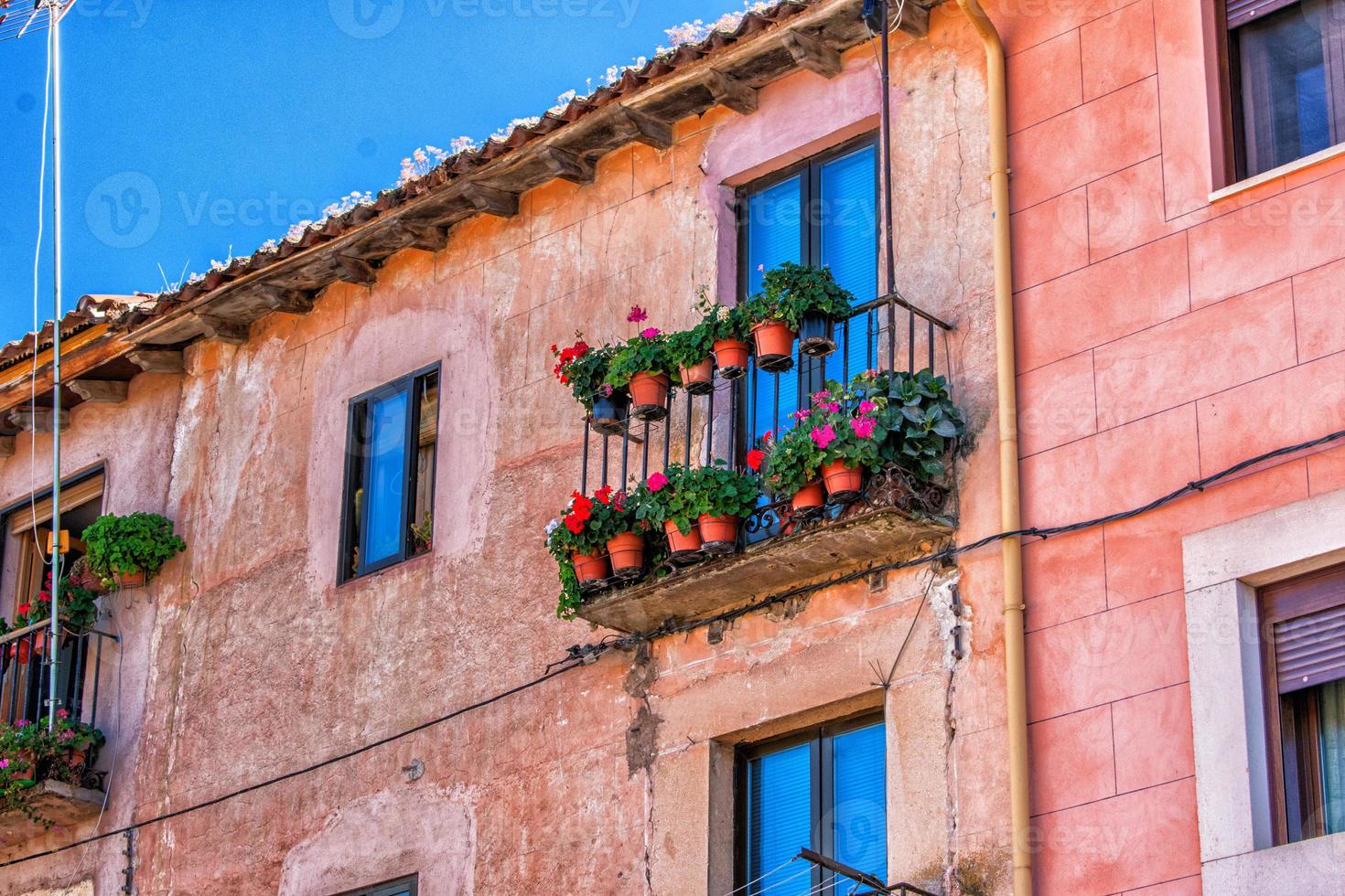 Fassade mit Balkon und Pflanzen im Sommer foto
