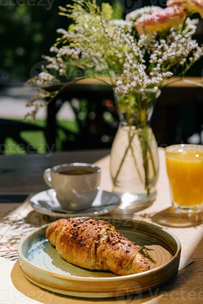 Tasse von frisch heiß Kaffee, Orange Saft und traditionell Französisch Croissant auf Tabelle von Pariser draussen Cafe im Paris foto