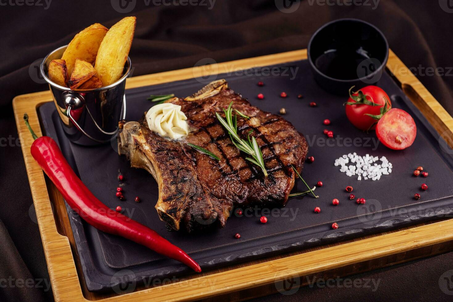 gegrillt Steak mit gebacken Kartoffeln und Gemüse serviert auf hölzern Tafel foto