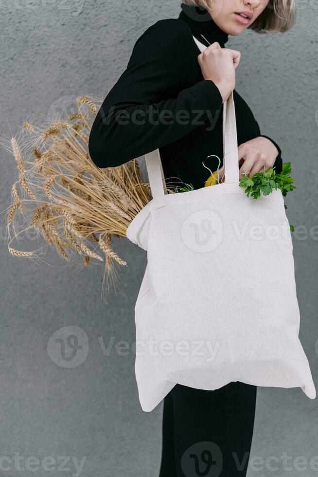 jung Mädchen halten ein Stoff Tasche mit Ohren von Weizen foto