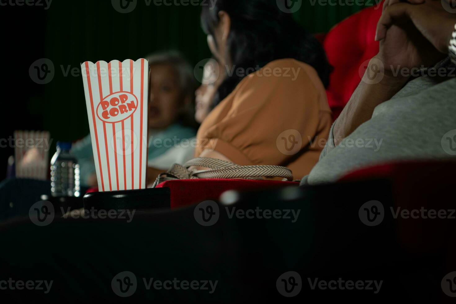 Kino Konzept. Menschen Aufpassen Film beim Kino trinken Wasser und Essen Popcorn foto