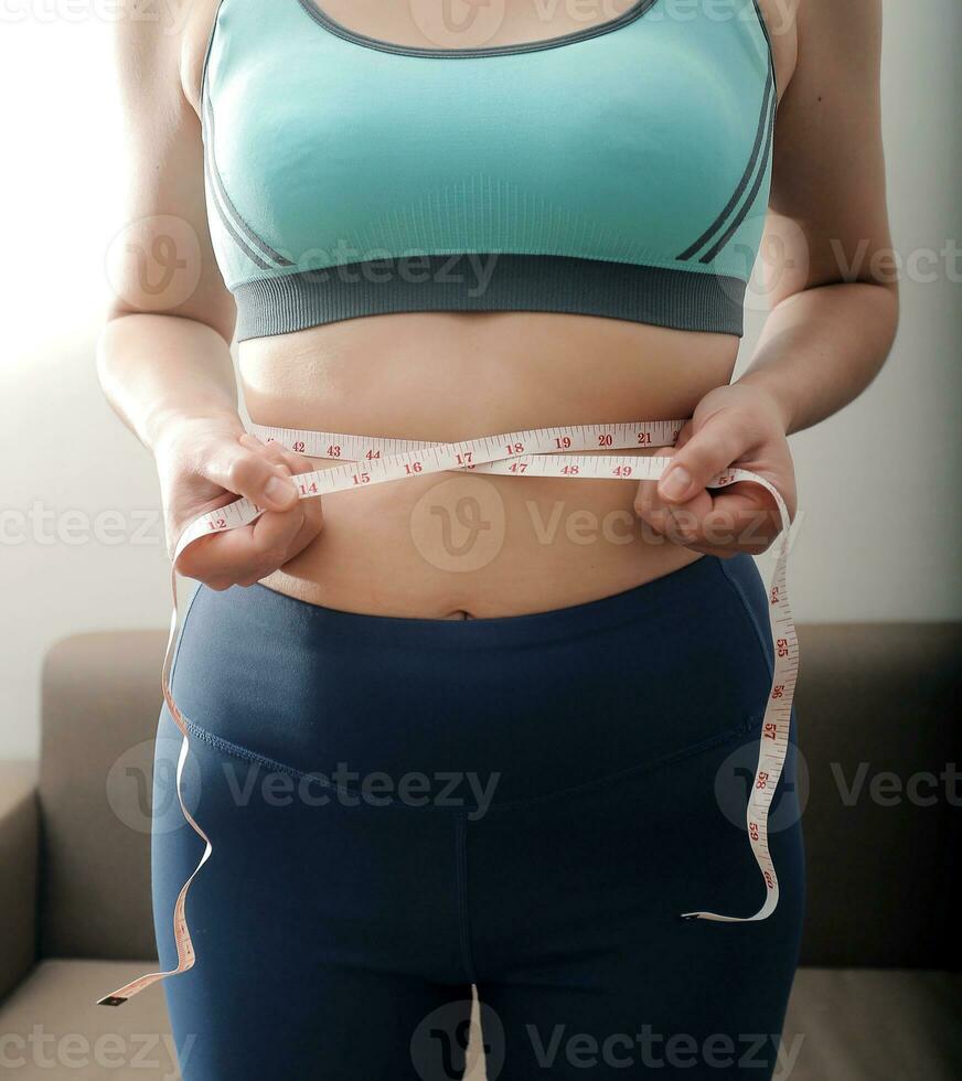 Frauen Körper Fett Bauch. fettleibig Frau Hand halten übermäßig Bauch fett. Diät Lebensstil Konzept zu reduzieren Bauch und gestalten oben gesund Bauch Muskel. foto