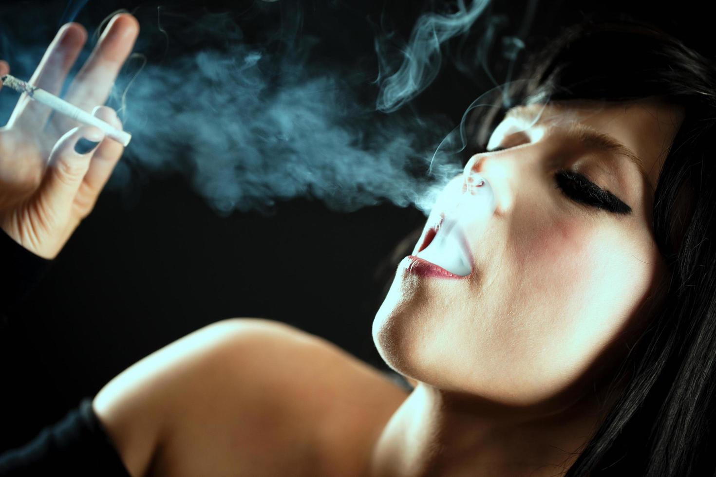 junge schöne Frau raucht Zigarette foto