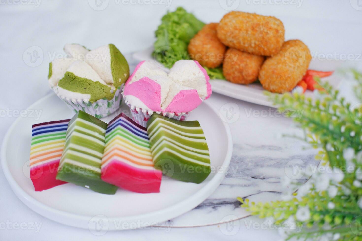 gebraten Kroketten, Schwamm Cupcake und Regenbogen klebrig Schicht Kuchen indonesisch traditionell Dessert foto