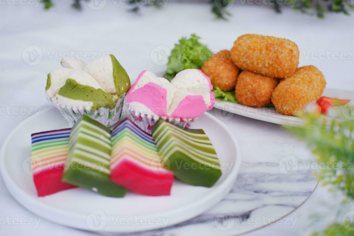 gebraten Kroketten, Schwamm Cupcake und Regenbogen klebrig Schicht Kuchen indonesisch traditionell Dessert foto