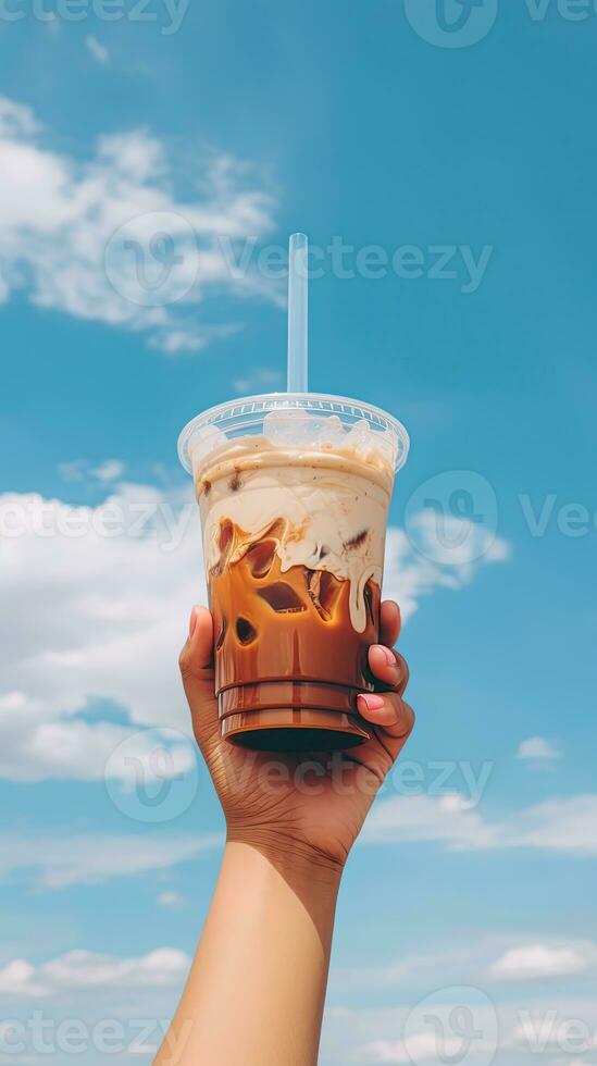 Hand halten vereist Kaffee im ein Plastik Tasse mit ein Blau Himmel und Wolke Hintergrund. ai generiert foto