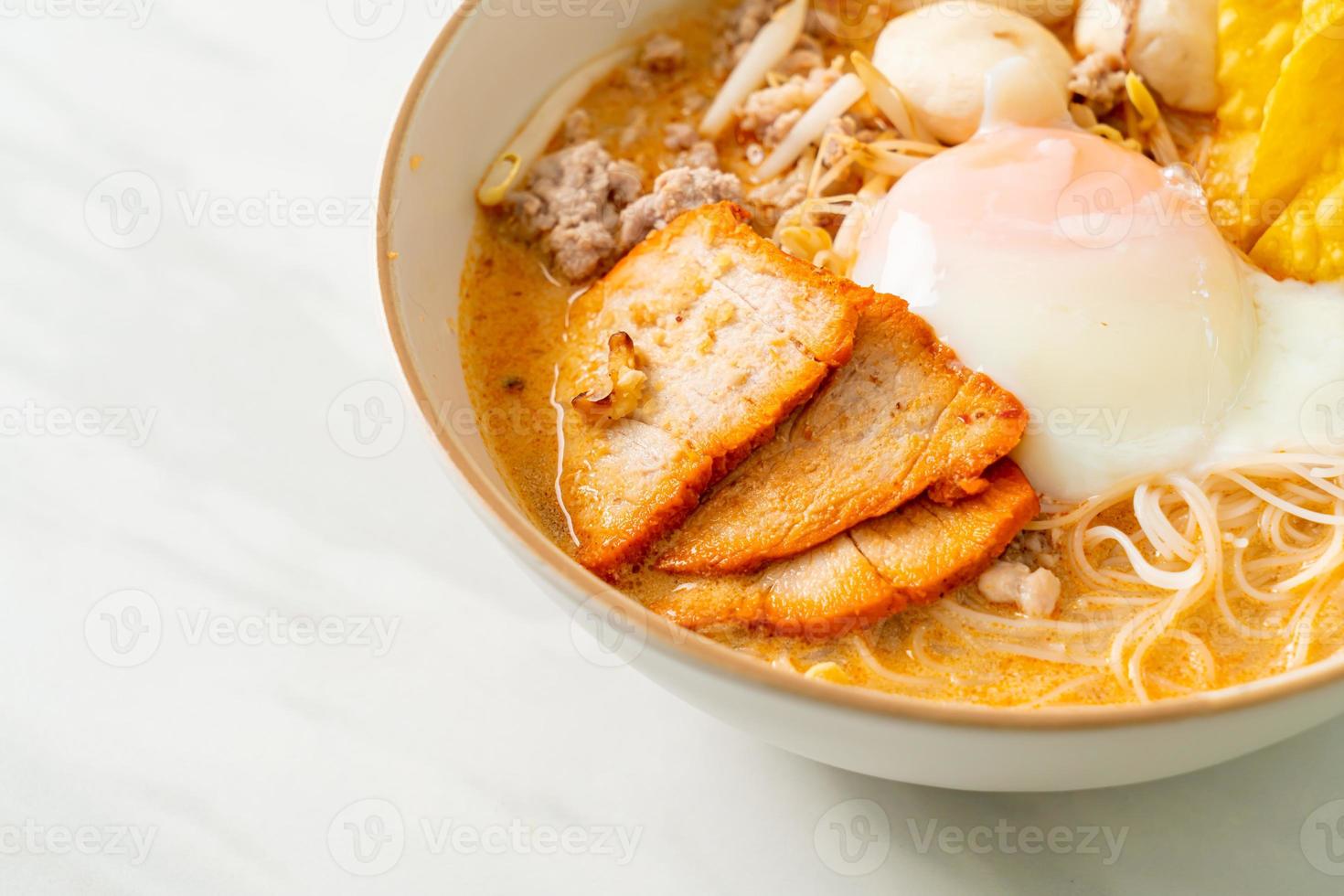 Reisfadennudeln mit Frikadellen, gebratenem Schweinefleisch und Ei in pikanter Suppe - Tom Yum Nudeln foto