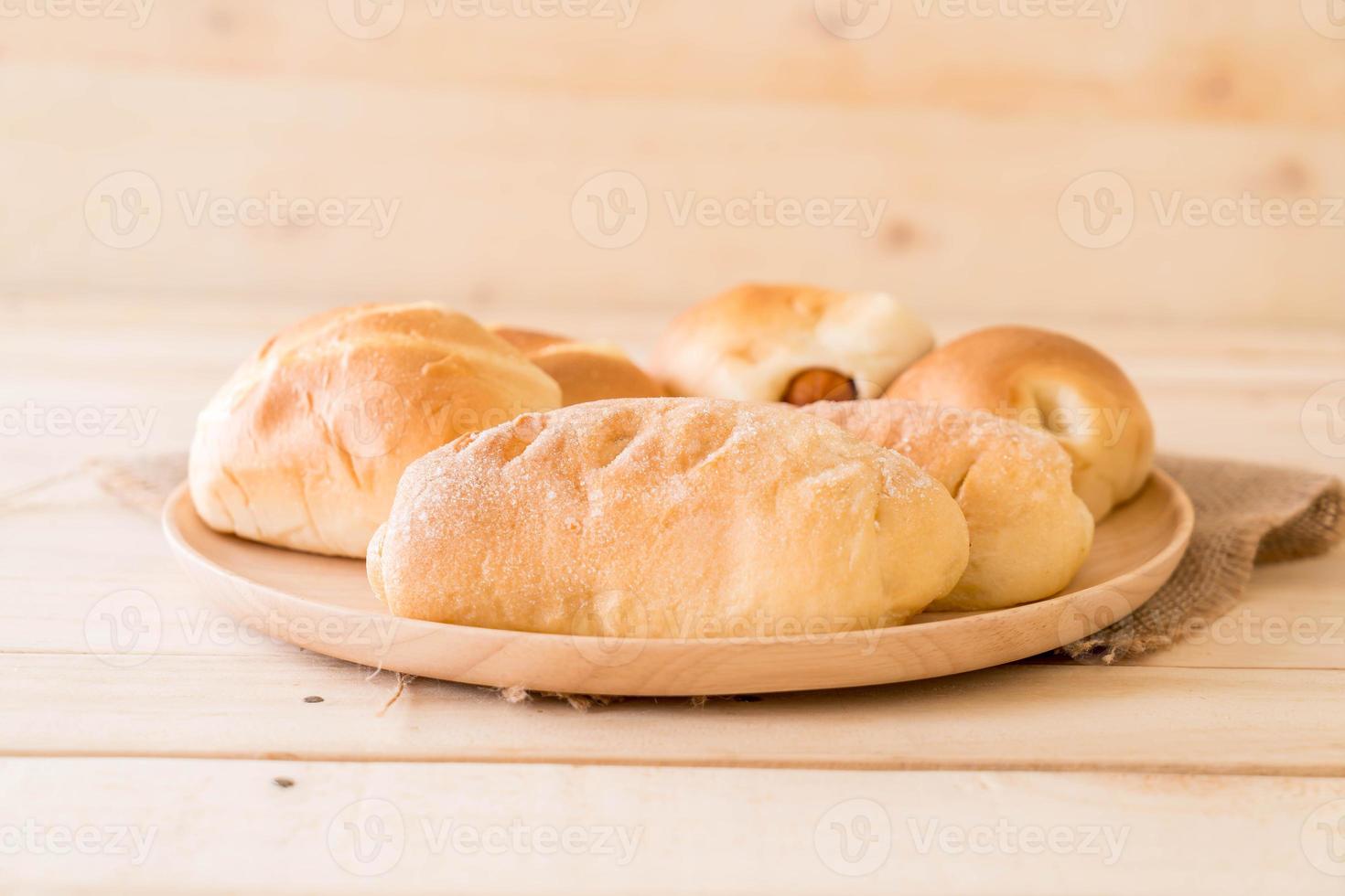 Brot in Holzplatte auf weißem Hintergrund foto