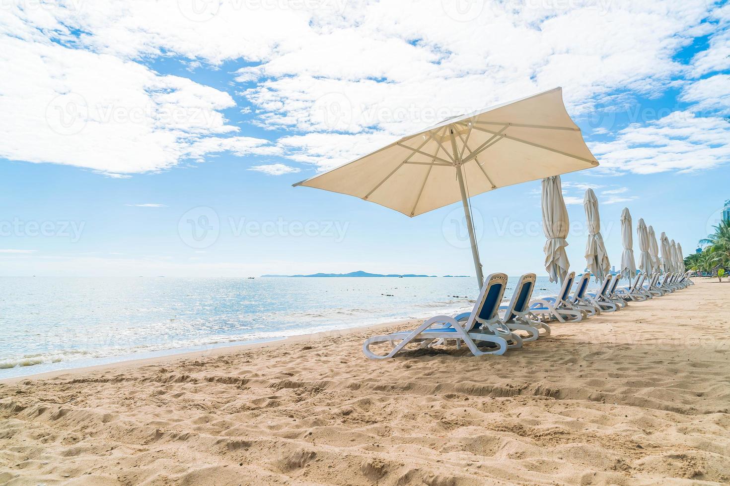 Outdoor mit Sonnenschirm und Stuhl am wunderschönen tropischen Strand und Meer foto