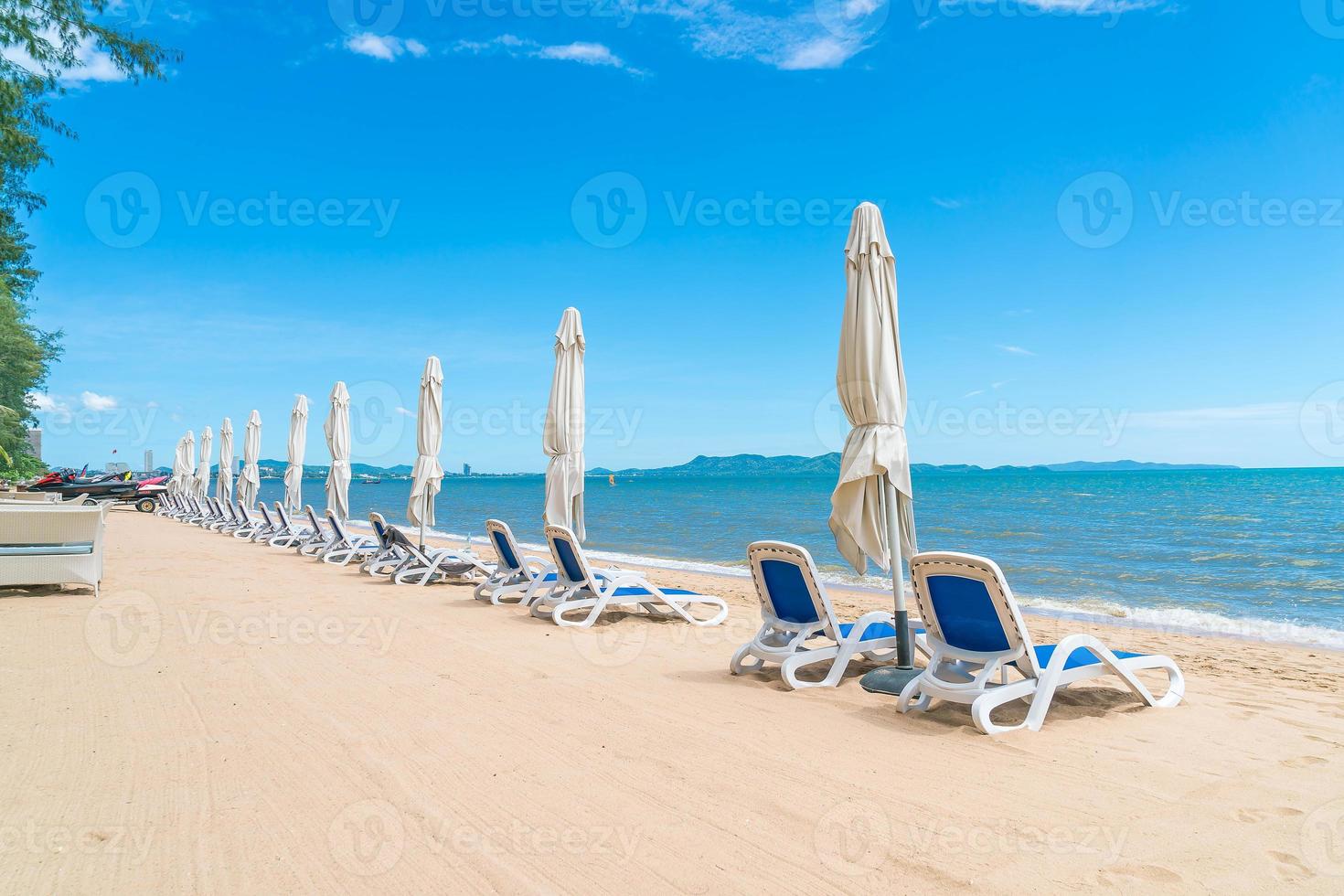 Outdoor mit Sonnenschirm und Stuhl am wunderschönen tropischen Strand und Meer foto