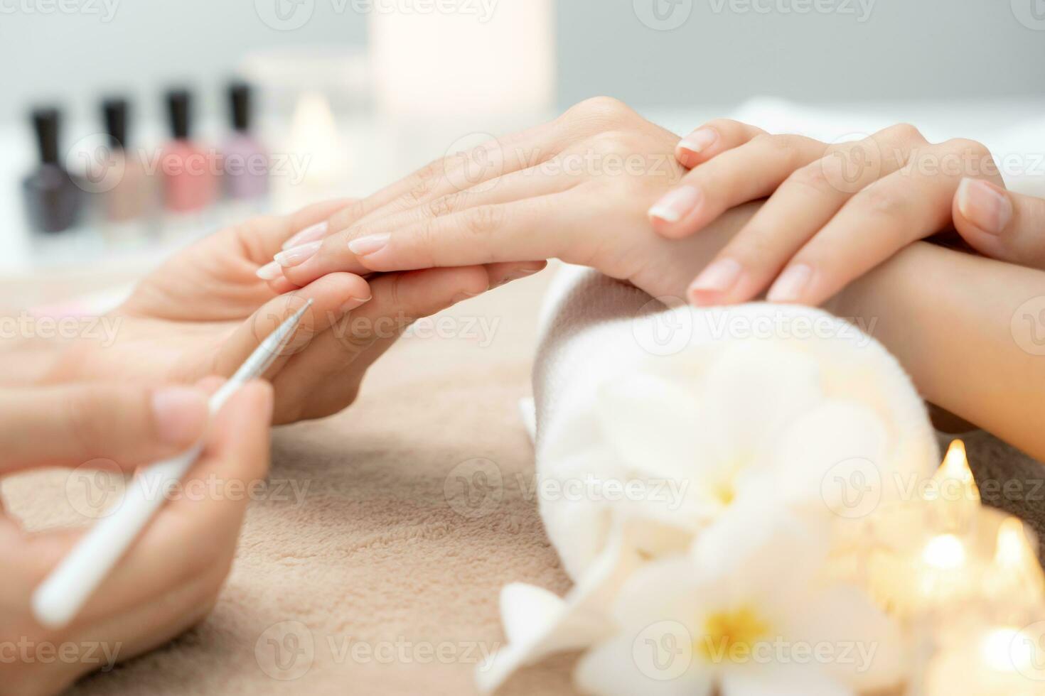 frau wird von einer professionellen kosmetikerin maniküre im spa-zentrum betreut. nagelschönheitssalon verwenden nagelfeile für die glasurbehandlung. Maniküre machen Nagelkunden schön. Spa-Behandlung für die Körperpflege foto