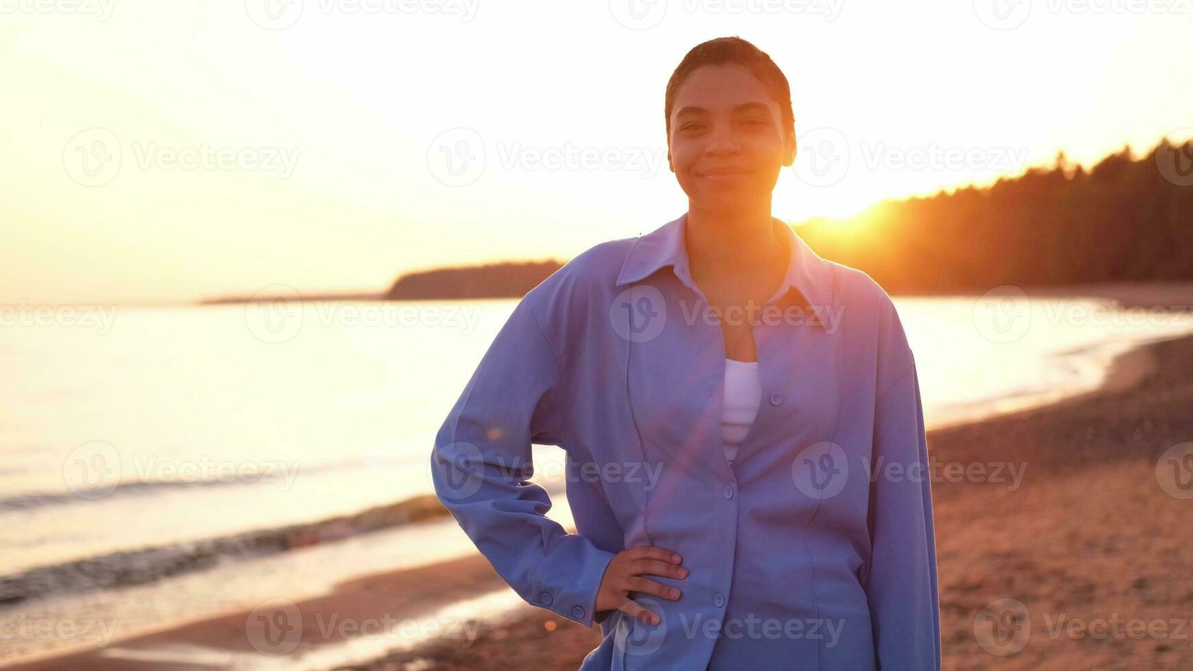 schön afrikanisch amerikanisch Mädchen lächelnd auf Sonnenuntergang. draussen Porträt von jung glücklich lächelnd schwarz Mädchen. jung afrikanisch Frau entspannend beim Strand. Freiheit Glück sorglos glücklich Menschen Konzept. foto