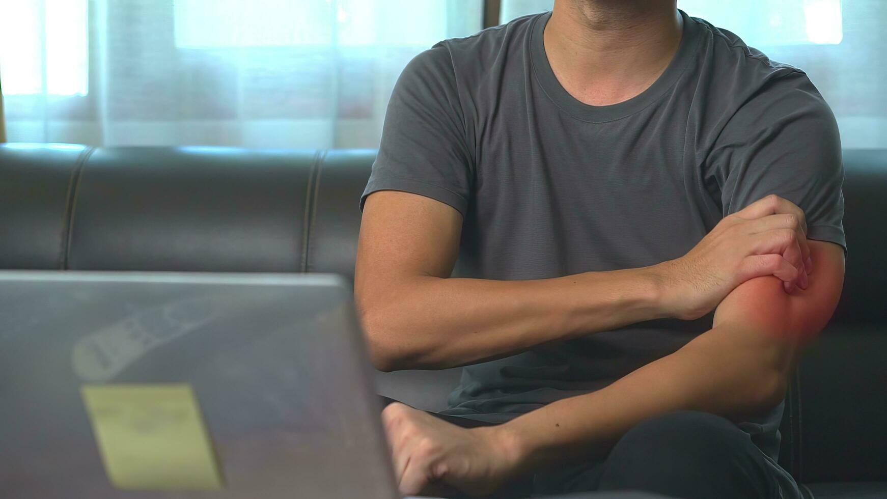 schließen oben Hand von asiatisch Mann er Massagen Arm tut weh mit Laptop zum lange Zeitraum von Zeit. Büro Verletzung Syndrom Konzept. foto