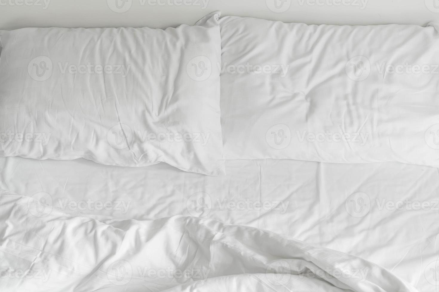 Randbett mit weißer unordentlicher Kissendekoration im Schlafzimmerinnenraum foto