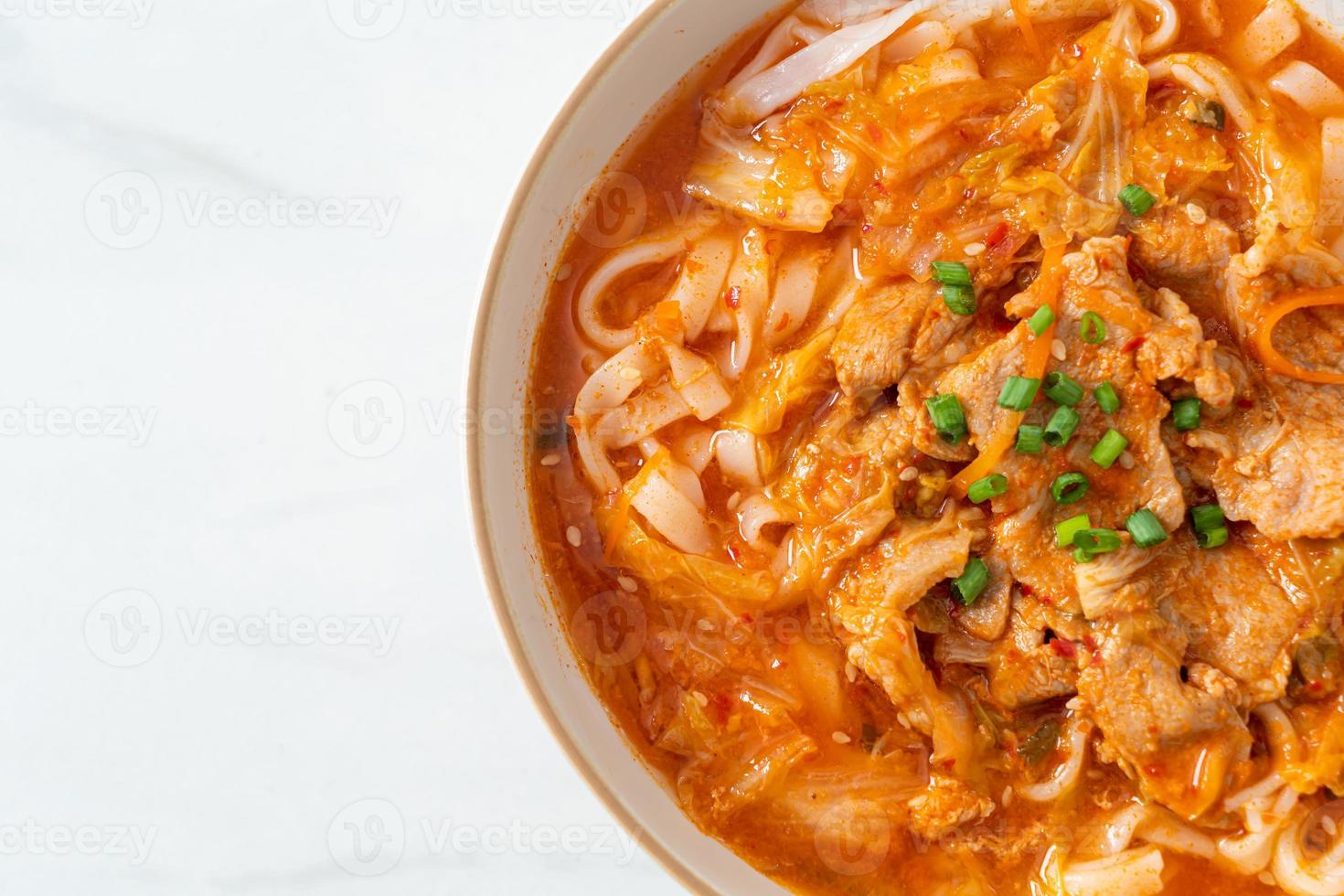 koreanische Udon-Ramen-Nudeln mit Schweinefleisch in Kimchi-Suppe foto