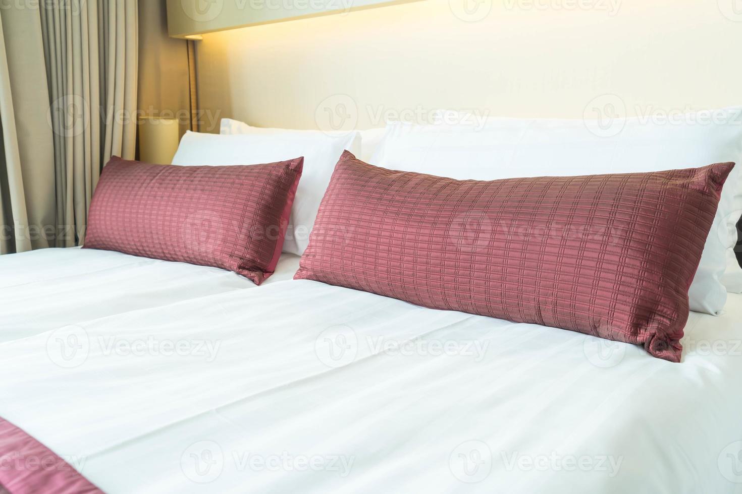 schönes Kissen auf Bettdekoration im Schlafzimmerinnenraum foto