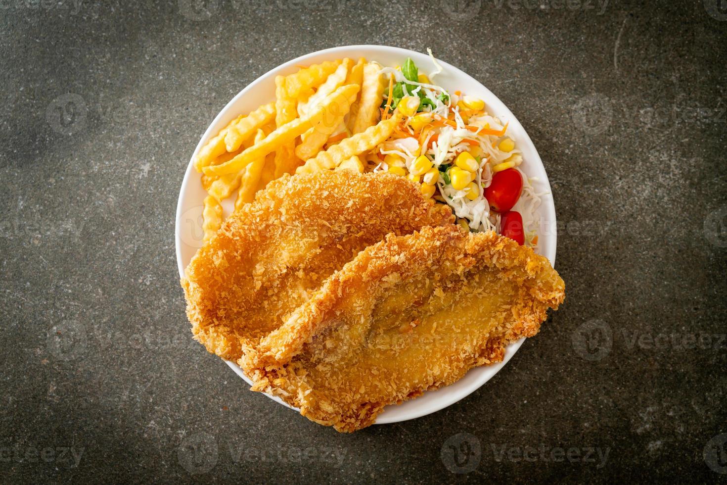 Fish and Chips mit Minisalat auf weißem Teller foto