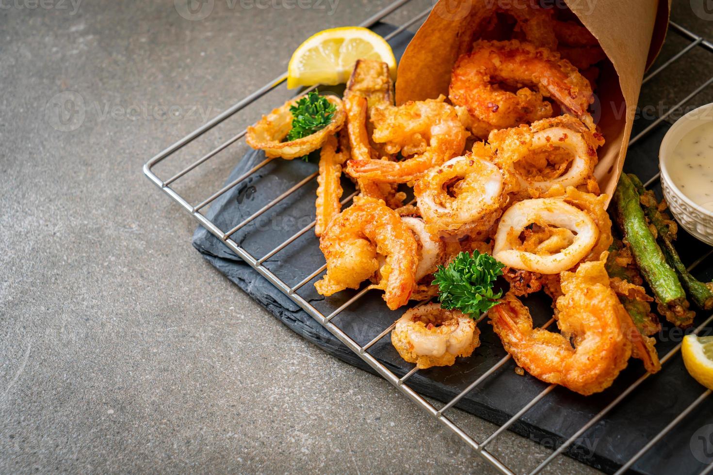 frittierte Meeresfrüchte von Garnelen und Tintenfisch mit gemischtem Gemüse - ungesunde Ernährungsweise foto