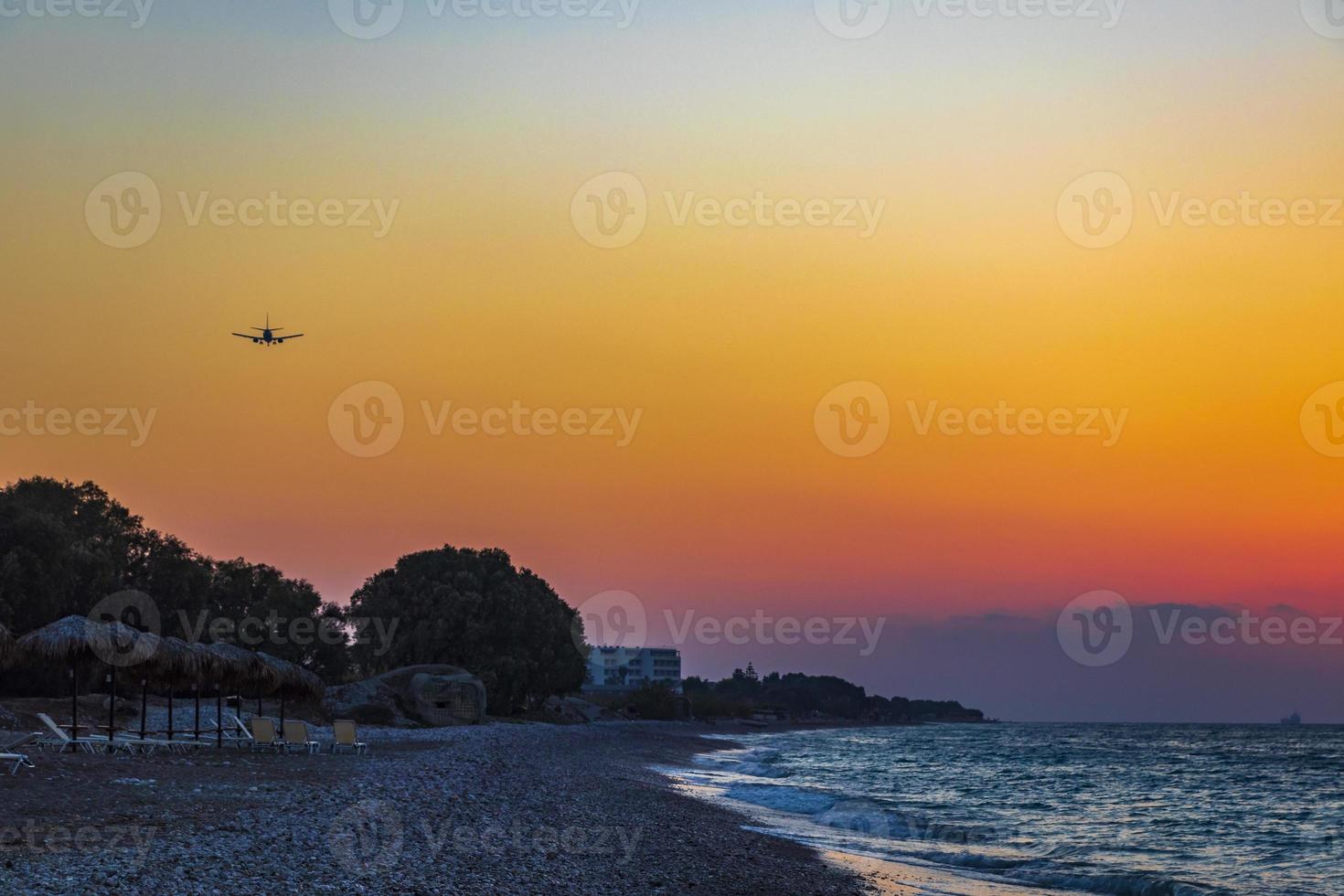 Flugzeug landet bei farbenfrohem Sonnenuntergang Ialysos Strand Rhodos Griechenland. foto