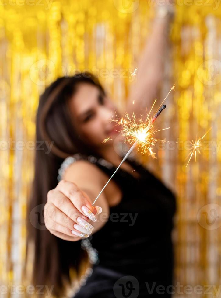 Frau mit Wunderkerze und Ballon auf goldenem Hintergrund foto