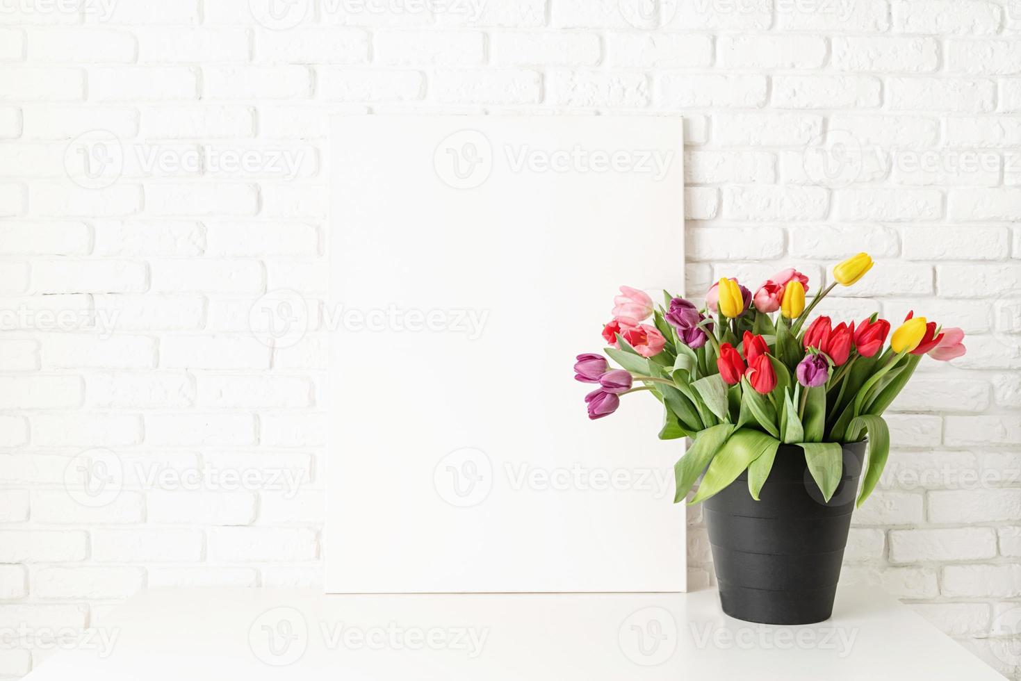 Mock-up mit Rahmen und Eimer Tulpen auf weißem Backsteinmauerhintergrund foto