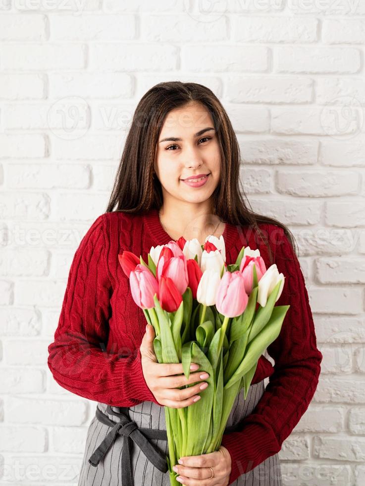 Floristin hält einen Strauß frischer bunter Tulpen foto