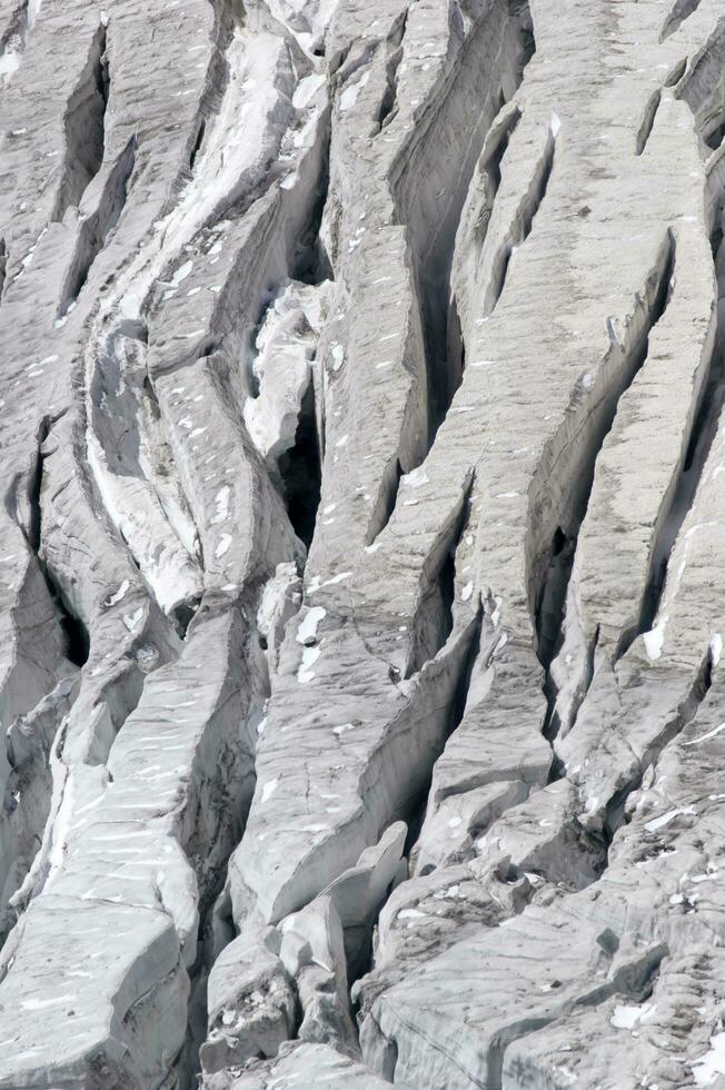 zwei Menschen sind Wandern oben ein Berg mit Schnee bedeckt Berge foto