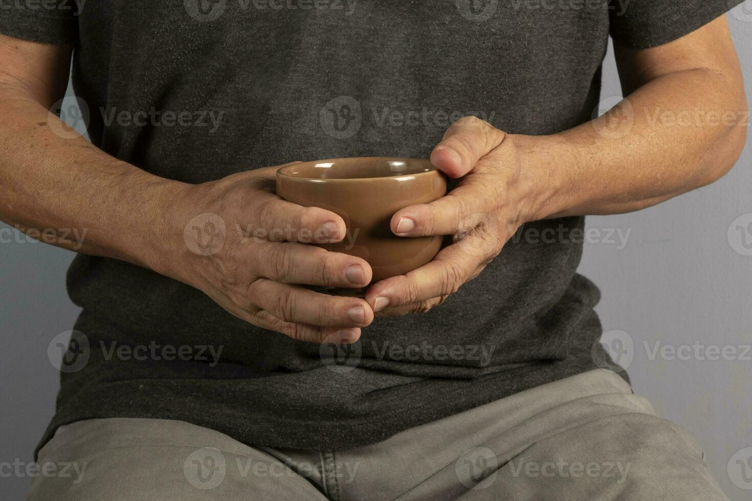 Hände von ein Alten Mann halten ein Becher mit ein heiß trinken foto