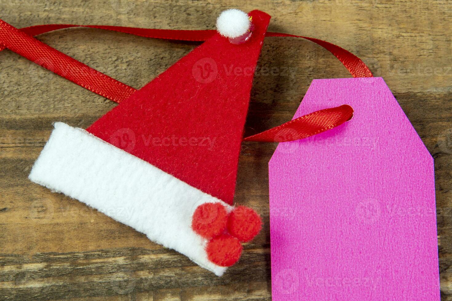 dekorative weihnachtselemente neben karte mit rotem band und platz zum schreiben foto