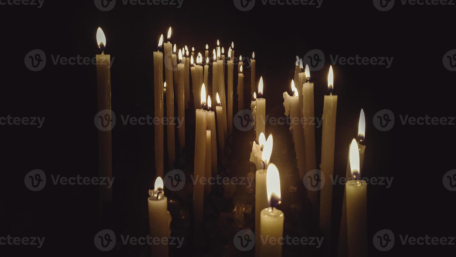 Kirchenkerzen im Dunkeln foto