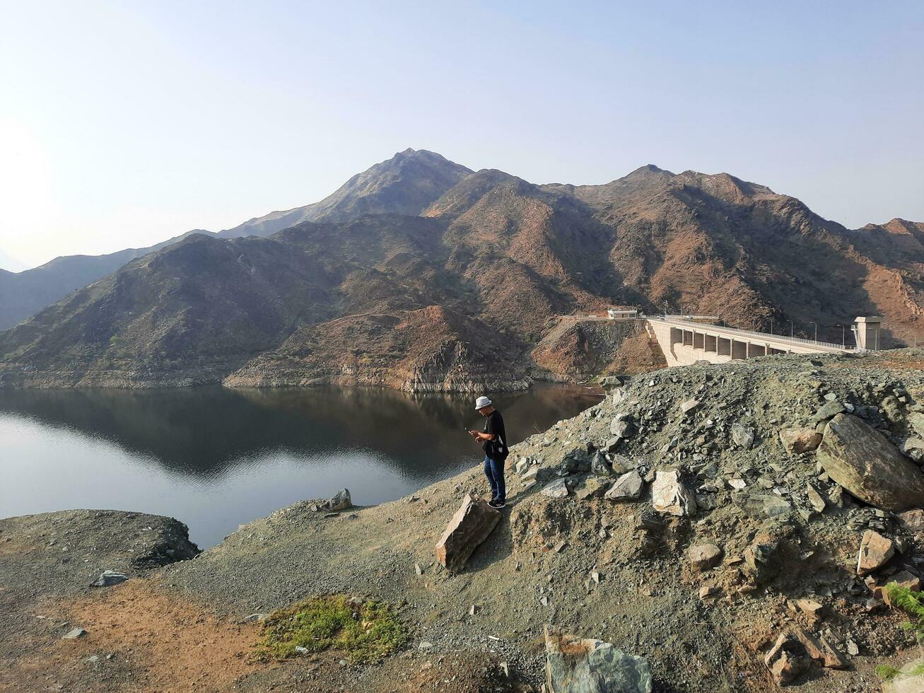 ein schön tagsüber Aussicht von Wadi qanuna Damm im al Bahah, Saudi Arabien. das Wasser von das Damm und das Umgebung Hügel sind präsentieren ein schön Szene im das Sonnenlicht. foto