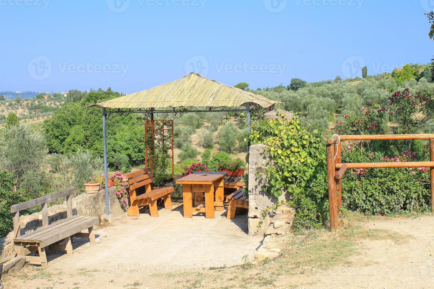 Holznische mit Tisch und Bänken im Sommer in der Toskana, Italien foto