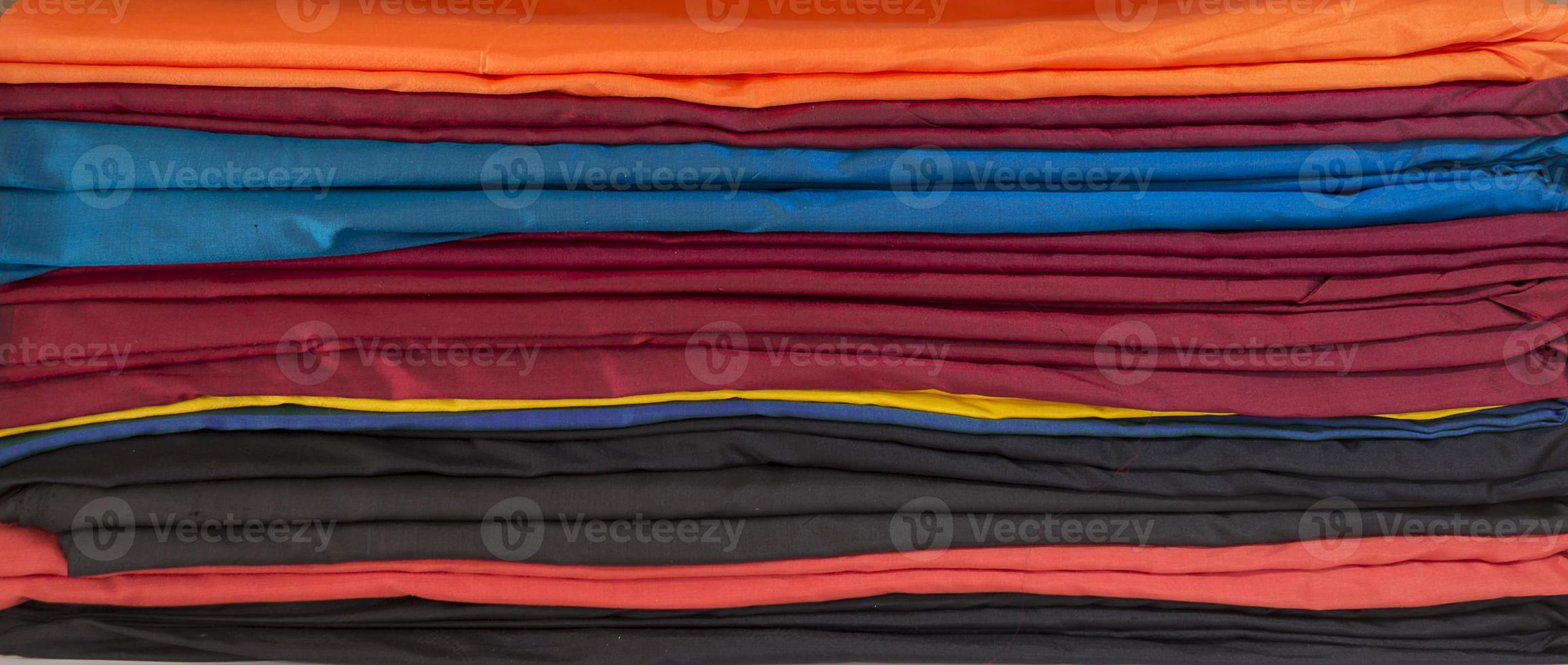 ein horizontaler Stapel gefalteter Stoffe in verschiedenen Farben foto