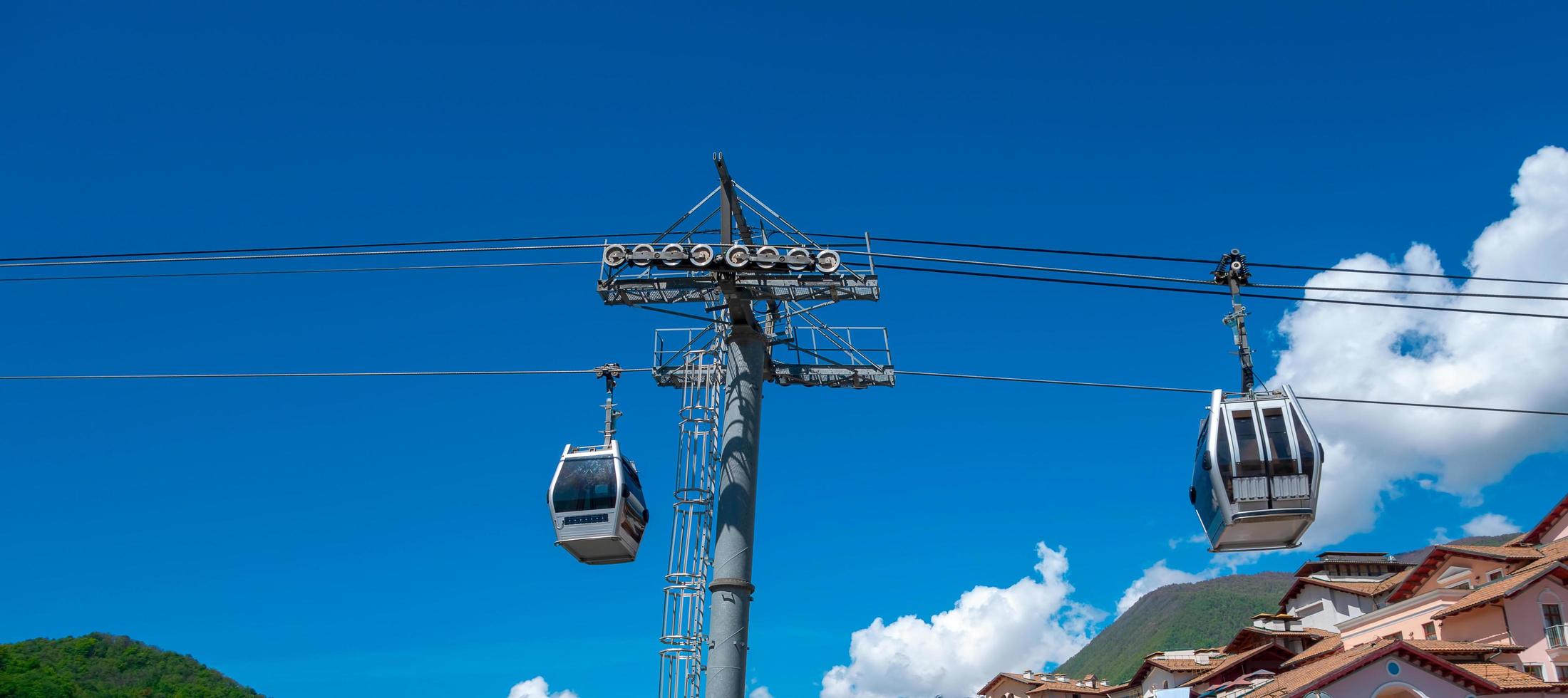 zwei Kabinen auf einer Seilbahn unter strahlend blauem Himmel foto