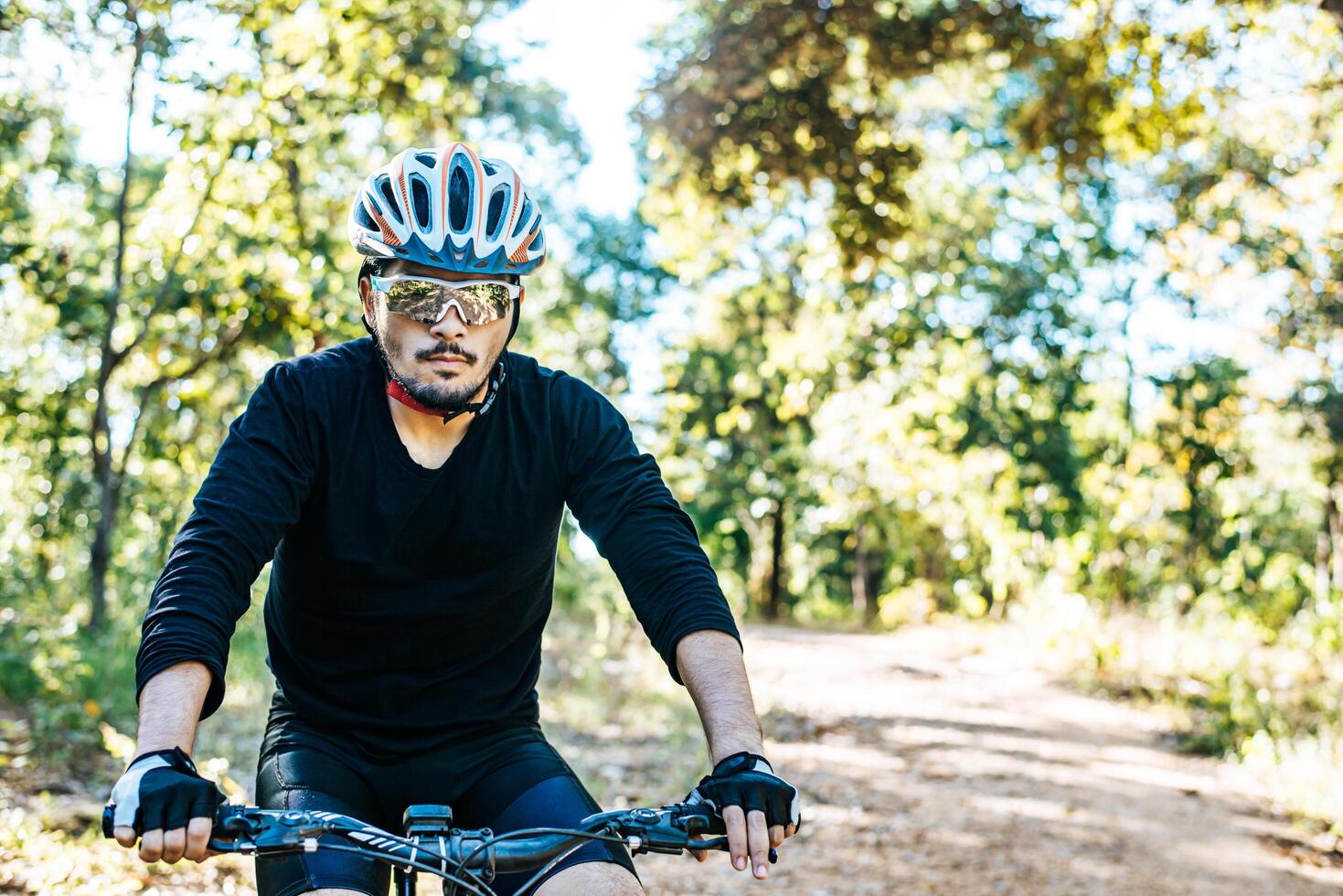 der Mann, der auf einem Bergpfad Fahrrad fährt a foto